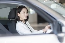 Китайська жінка, що сидить у автомобіль на стоянці — стокове фото