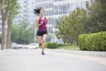 Donna cinese che corre per strada — Foto stock