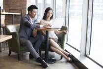 Азіатські чоловік і жінка, які працюють з ноутбуком в кафе — стокове фото