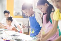 Bambini cinesi che dipingono in classe d'arte con insegnante — Foto stock