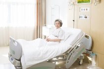 Chinese senior woman in hospital bed — Stock Photo