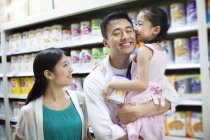 Menina chinesa beijando pai no supermercado — Fotografia de Stock