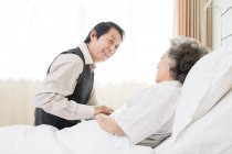 Chino senior hombre visitando esposa en hospital - foto de stock