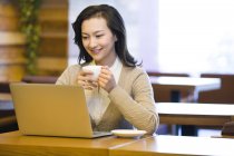 Mulher chinesa usando laptop no café — Fotografia de Stock