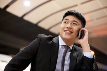 Chinesischer Geschäftsmann telefoniert am Bahnhof — Stockfoto