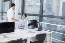 Empresários chineses conversando e sorrindo no escritório — Fotografia de Stock