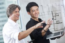 Male designers drawing sketch on glass wall — Stock Photo