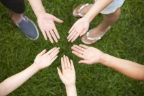 Cropped view of friends putting hands together — Stock Photo