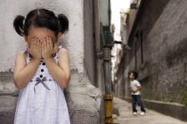 Menina chinesa cobrindo os olhos enquanto joga esconder e procurar — Fotografia de Stock