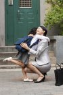Cinese donna e studentessa abbraccio su strada — Foto stock