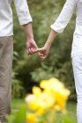 Cropped view of couple holding little fingers — Stock Photo