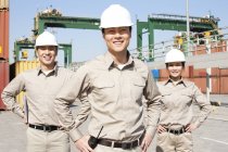 Chinese shipping industry workers with hands on hips — Stock Photo