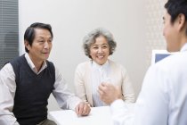 Médico chinês que explica a dosagem da medicina ao par sênior — Fotografia de Stock