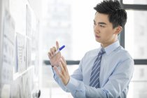 Empresário chinês trabalhando com quadro branco no escritório — Fotografia de Stock