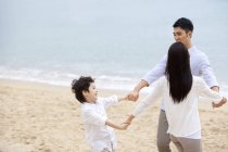 Pais chineses com filho se divertindo na praia — Fotografia de Stock