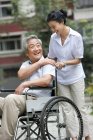 Старший китаєць в інвалідному візку з зрілий дружина — стокове фото