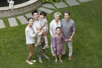 Vue grand angle de la famille chinoise regardant vers le haut à la pelouse verte — Photo de stock