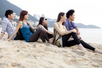 Група китайських друзів, сидячи на пляжі затоки відсіч, Сполучені Штати Америки — стокове фото