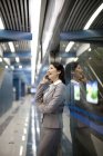 Chinesische Geschäftsfrau telefoniert in U-Bahn-Station — Stockfoto