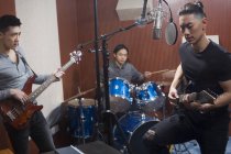 Китайская музыкальная группа записывает песню в студии — стоковое фото
