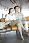 Casal chinês esperando no lounge do aeroporto — Fotografia de Stock