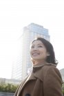 Portrait of smiling Chinese woman in downtown — Stock Photo
