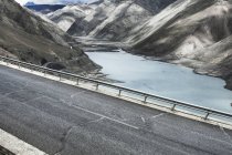 Живописный вид на горную дорогу и озеро в Тибете, Китай — стоковое фото