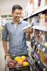 Chinese man shopping in supermarket — Stock Photo