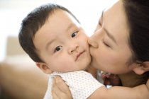 Donna cinese baciare figlio neonato — Foto stock