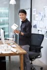 Arquitecto chino de pie en la oficina - foto de stock