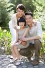 Portrait of Chinese family with daughter in garden — Stock Photo