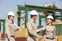 Chinese shipping industry workers talking at dock — Stock Photo