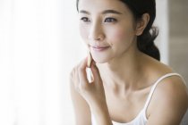 Jeune femme chinoise appliquant de la poudre visage — Photo de stock