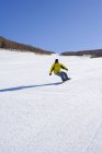 Young Chinese man snowboarding at ski resort — Stock Photo