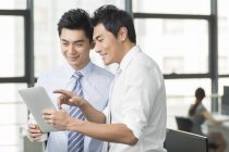 Uomini d'affari cinesi che utilizzano tablet digitale in ufficio — Foto stock