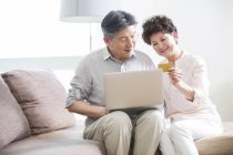 Senior Chinese couple shopping online with laptop — Stock Photo
