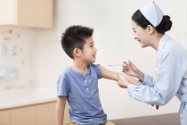 Enfermera china dando chico inyección - foto de stock