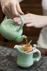 Крупним планом жіночі руки наливають чай — стокове фото