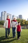 Chinese grandparents and grandson walking in park in autumn — Stock Photo