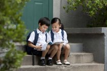 Китайський хлопчик і дівчинка вивчення на ганку — стокове фото
