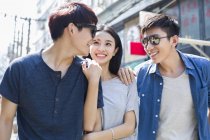 Casal chinês com amigo andando juntos na rua — Fotografia de Stock
