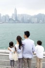 Vista trasera de la familia disfrutando de hermosos paisajes de Victoria Harbor, Hong Kong - foto de stock