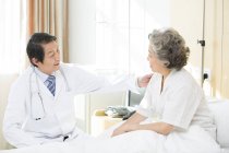 Médico chinês conversando com paciente no hospital — Fotografia de Stock