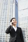 Китайський підприємець говорити на телефон перед високе-збільшення — стокове фото