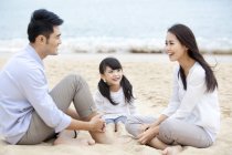 Chinese family resting on beach sand — Stock Photo