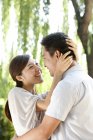 Giovane coppia cinese che abbraccia sotto il salice nel parco — Foto stock