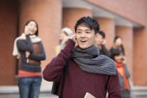 Étudiants chinois parlant sur les téléphones sur le campus — Photo de stock