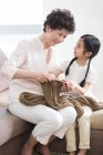 Chinese grandmother and granddaughter knitting in living room — Stock Photo