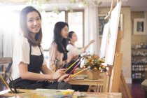 Jóvenes mujeres chinas pintando en estudio - foto de stock