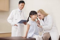 Лікарі вивчають вухо дівчини в лікарні — стокове фото